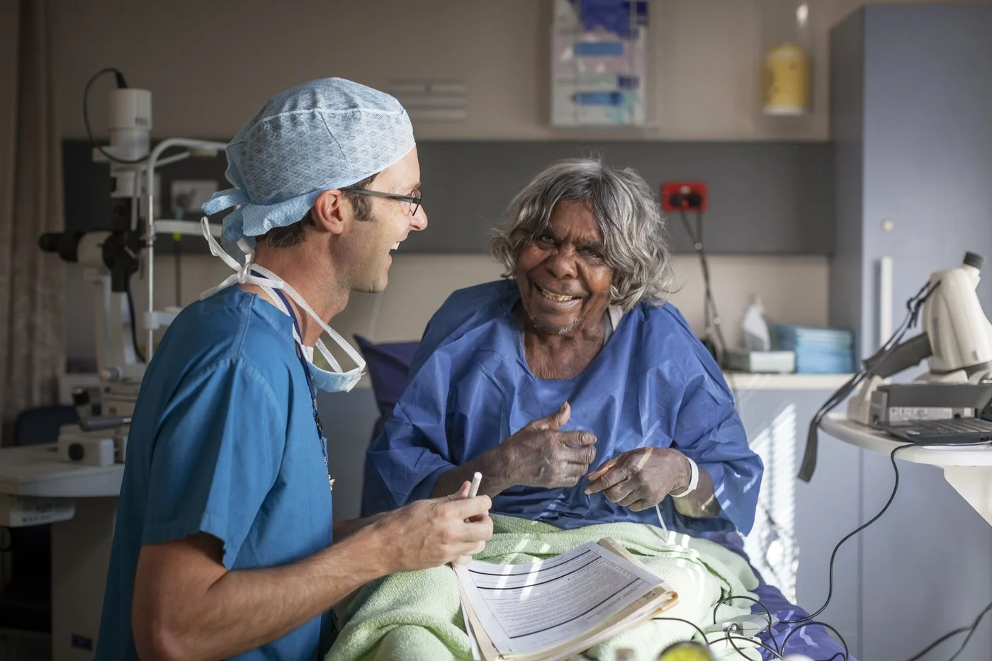 Eye health worker speaking with a patient in a clinical setting